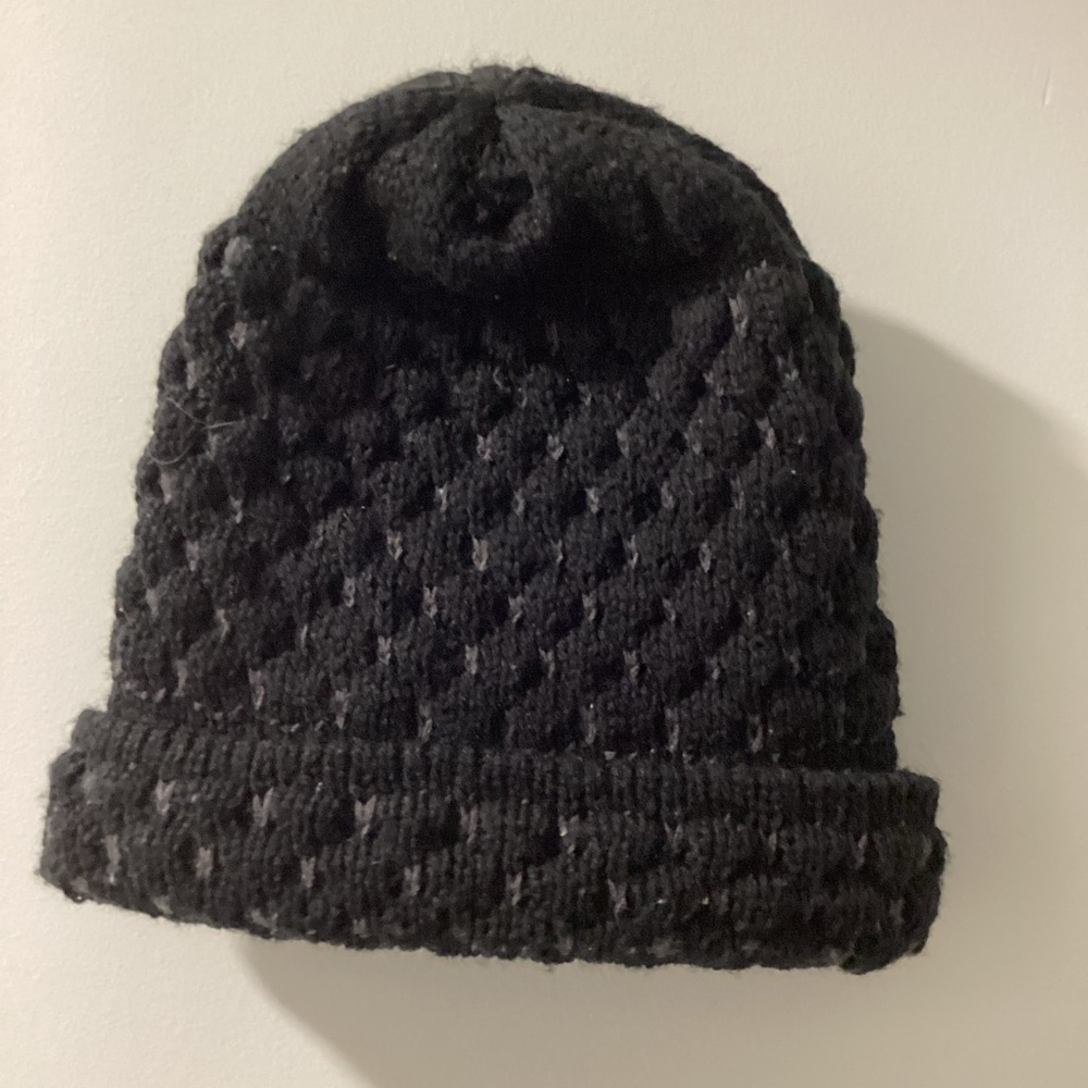 Preowned black knitted beanie hat with gray stitching.